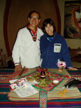 A man and woman standing in front of a table.