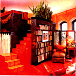 A living room with a bookshelf and stairs
