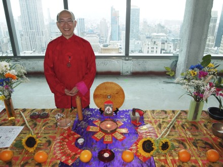 A man in red is standing next to an altar.