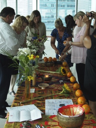 A group of people standing around a table with flowers.
