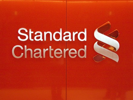 A red wall with the word standard chartered written on it.