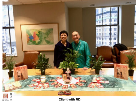 A couple of people standing in front of a table.